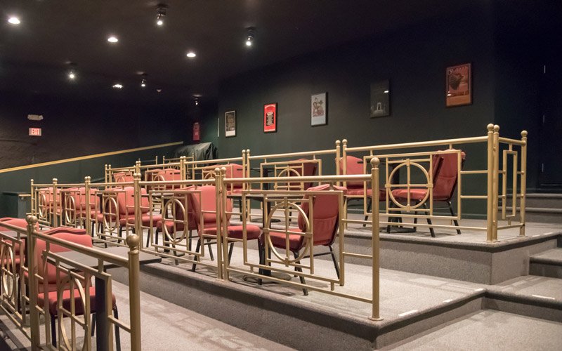 Rows of red theater seats arranged behind gold railings in the dark auditorium of the Elbert Theatre in Elberton, GA.