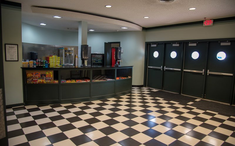 The Elbert Theatre concession stand features a black and white checkered floor and three exit doors.